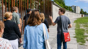 Group touring Berlin Wall with a guide.