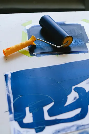 Farbrolle mit blauer Tinte auf Weiß.