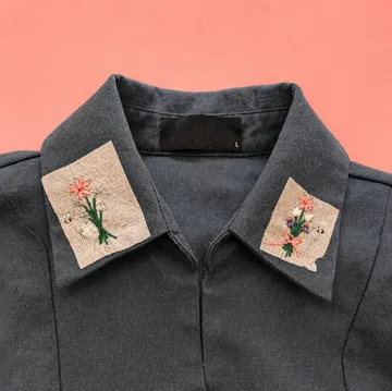 Shirt collar with embroidered patches, red background.