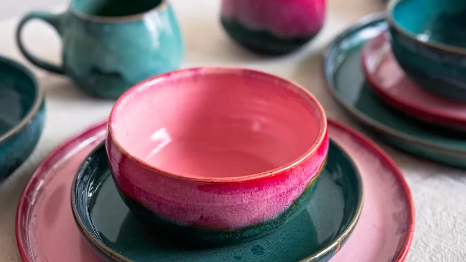 Colorful ceramic bowls and plates on table.