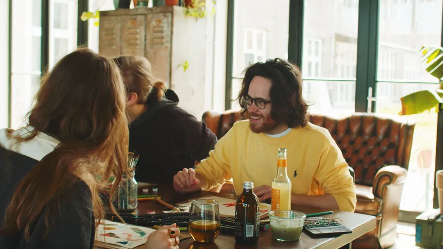People chatting and painting at a cozy table.
