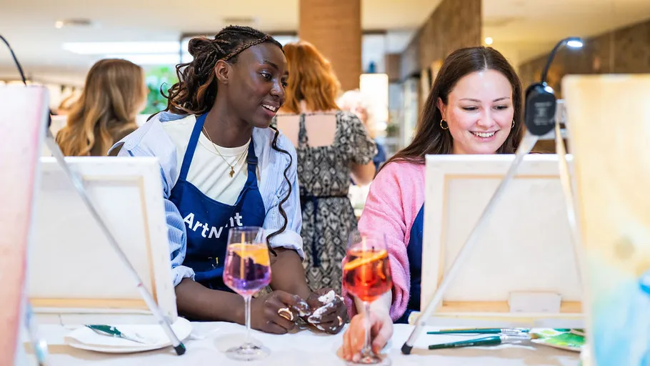 Two women painting together at a table.