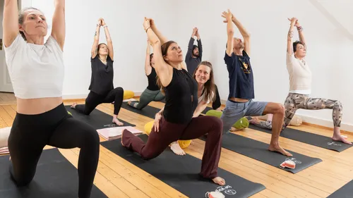 Gruppe macht Yoga-Posen in einem Studio.