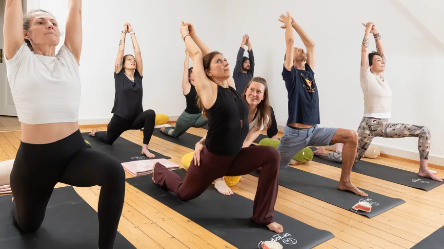 Group doing yoga poses in a studio.