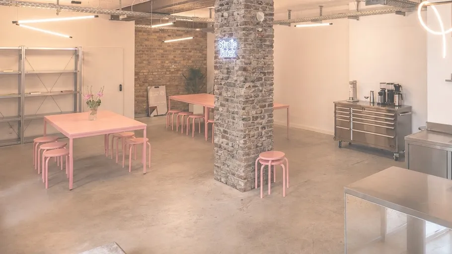 Modern kitchen with pink tables and stools.