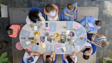Menschen basteln an einem Tisch mit Materialien.