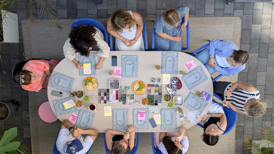 People crafting at a table with supplies.