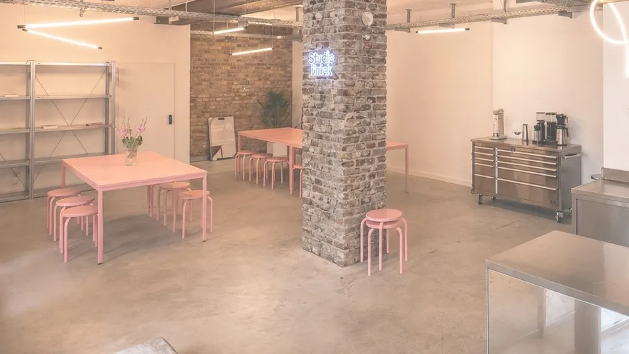 Modern industrial kitchen with pink tables.