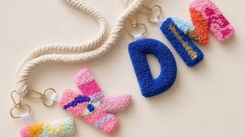 Colorful plush keychains spell 'DIM'.