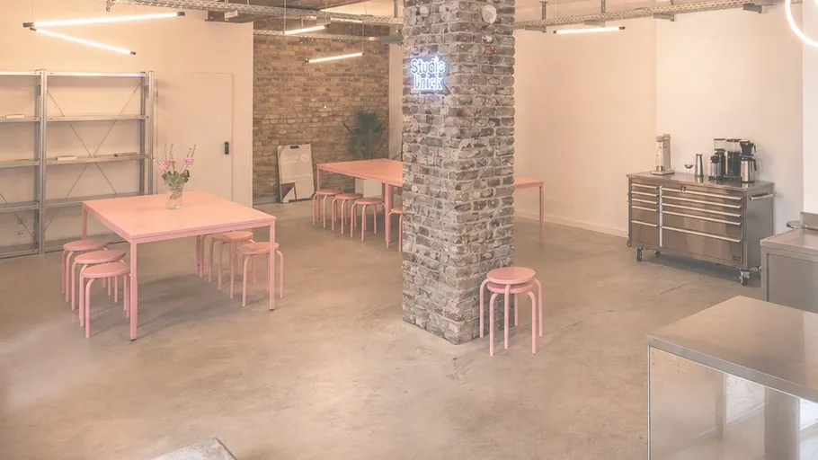 Modern dining area with pink tables and chairs.