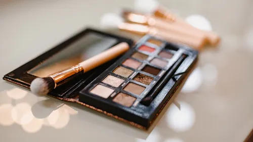 Make-up-Palette und Pinsel auf einem Tisch.