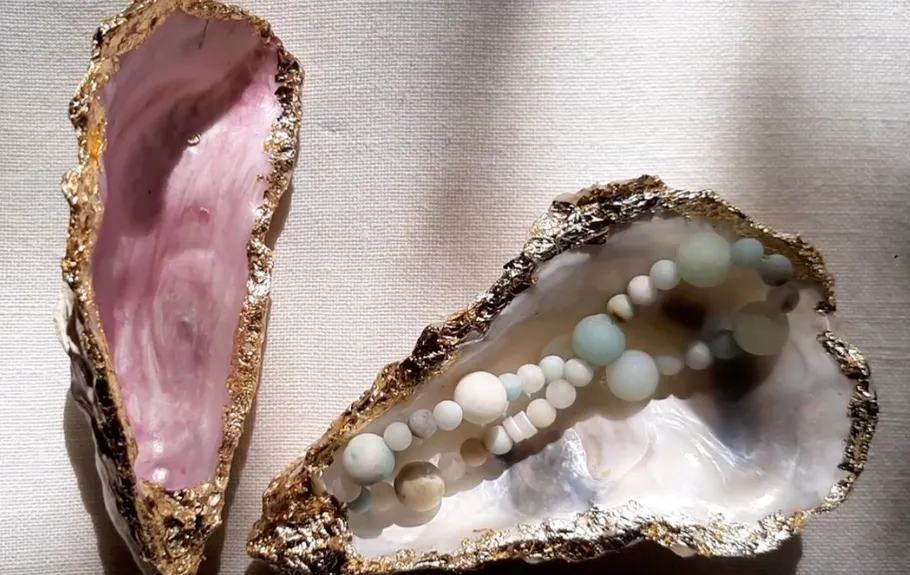 Two decorated oyster shells with beads inside.