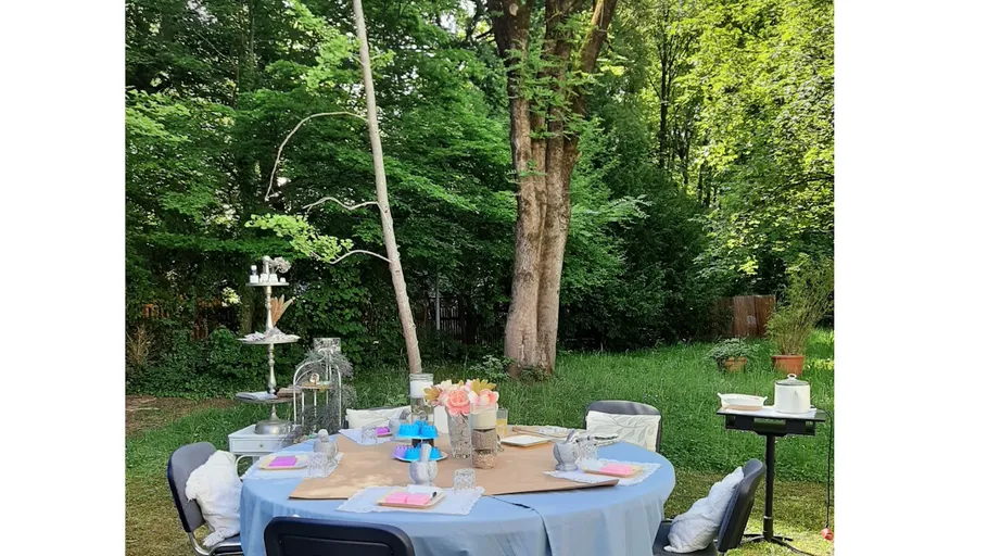 Decorated table in a garden with trees.