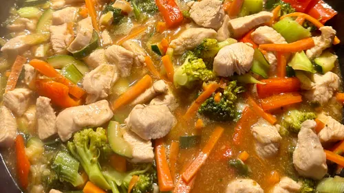 Hähnchen und Gemüse in Sauce kochen.