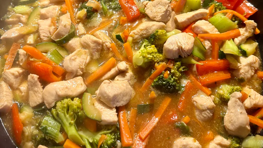 Hähnchen und Gemüse in Sauce kochen.