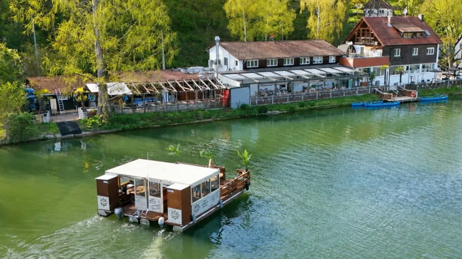 River raft floating near riverside houses.