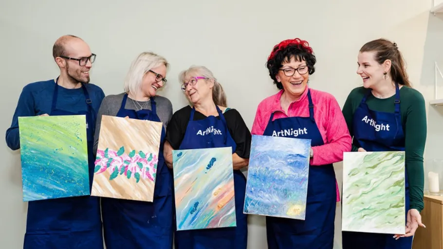 Five people holding abstract paintings, smiling together.