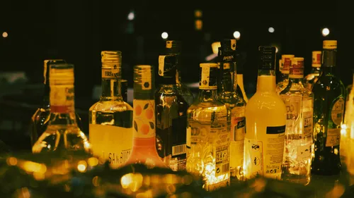 Assorted liquor bottles on a dimly lit bar.