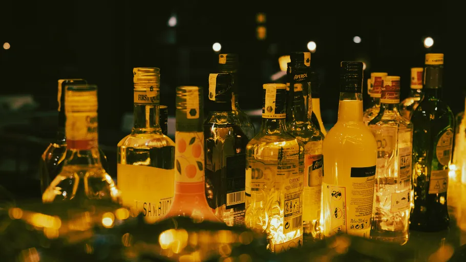 Assorted liquor bottles on a dimly lit bar.