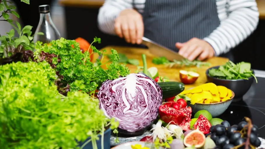 Person chopping vegetables in a kitchen setting.