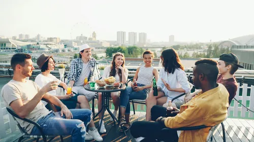 Gruppe von Freunden genießt Getränke auf Dachterrasse.