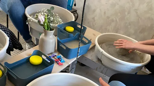 Hände formen Ton auf Töpferscheibe drinnen.