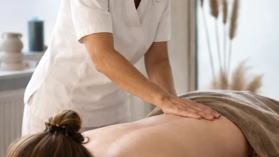 Person erhält Rückenmassage in ruhigem Raum.