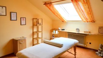 Massage table in cozy, sunlit room.