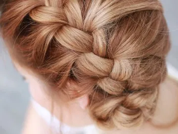 Geflochtene Haare liegen elegant auf dem Kopf.