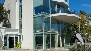 Modernes Gebäude mit Glasfassade und Balkonen.