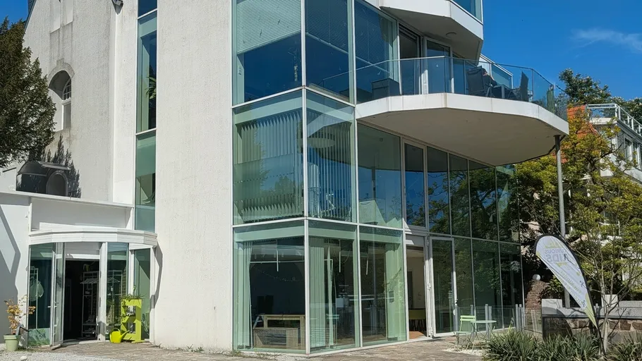 Modernes Gebäude mit Glasfassade und Balkonen.