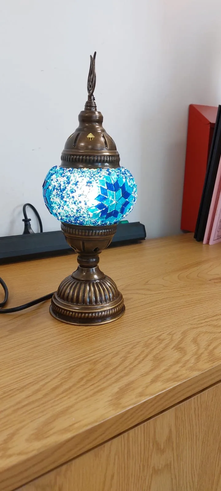 Mosaic lamp with blue light on wooden table.
