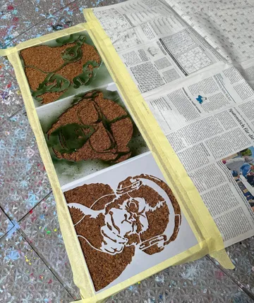 Stencils of a monkey with headphones on floor.
