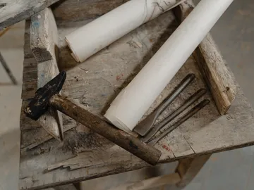 Hammers and tools lie on a dusty table.