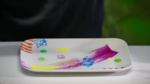 Bunt bemalter Teller auf weißer Fläche.
