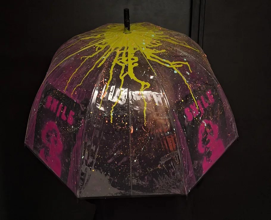 Colorful umbrella with abstract design in darkness.