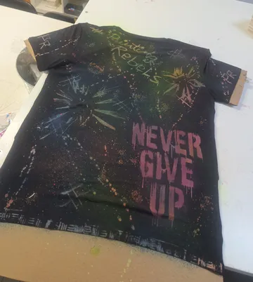 Schwarz gesprenkeltes T-Shirt mit motivierendem Text.