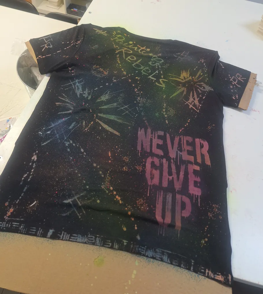 Schwarz gesprenkeltes T-Shirt mit motivierendem Text.