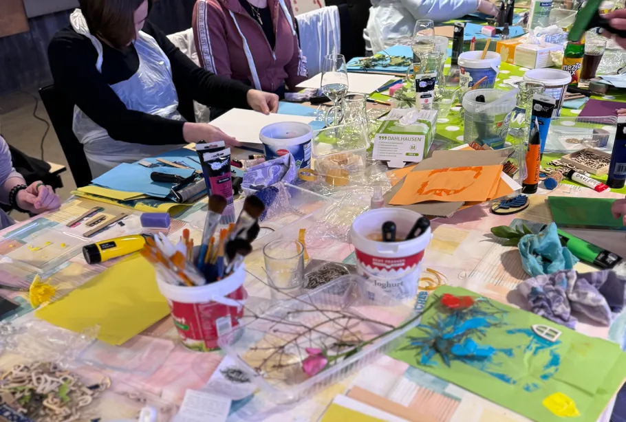 People crafting diverse art projects at tables.