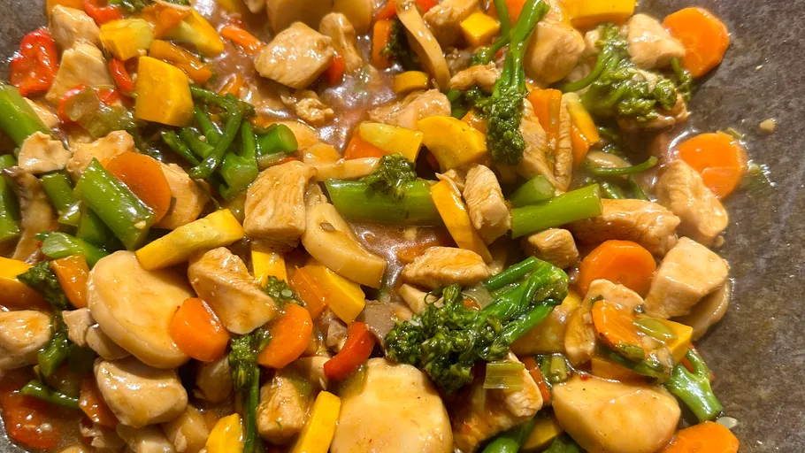 Mixed vegetables and chicken stir-fry in a pan.