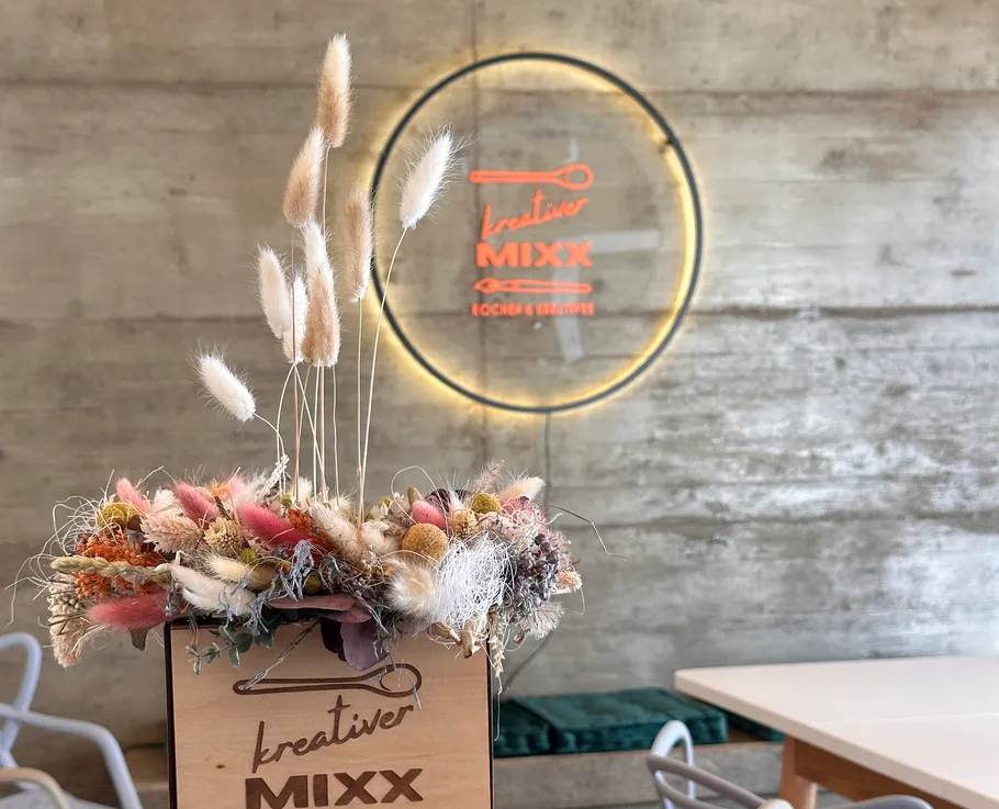 Trockenblumen in einer Box, Leuchtschild an Wand.