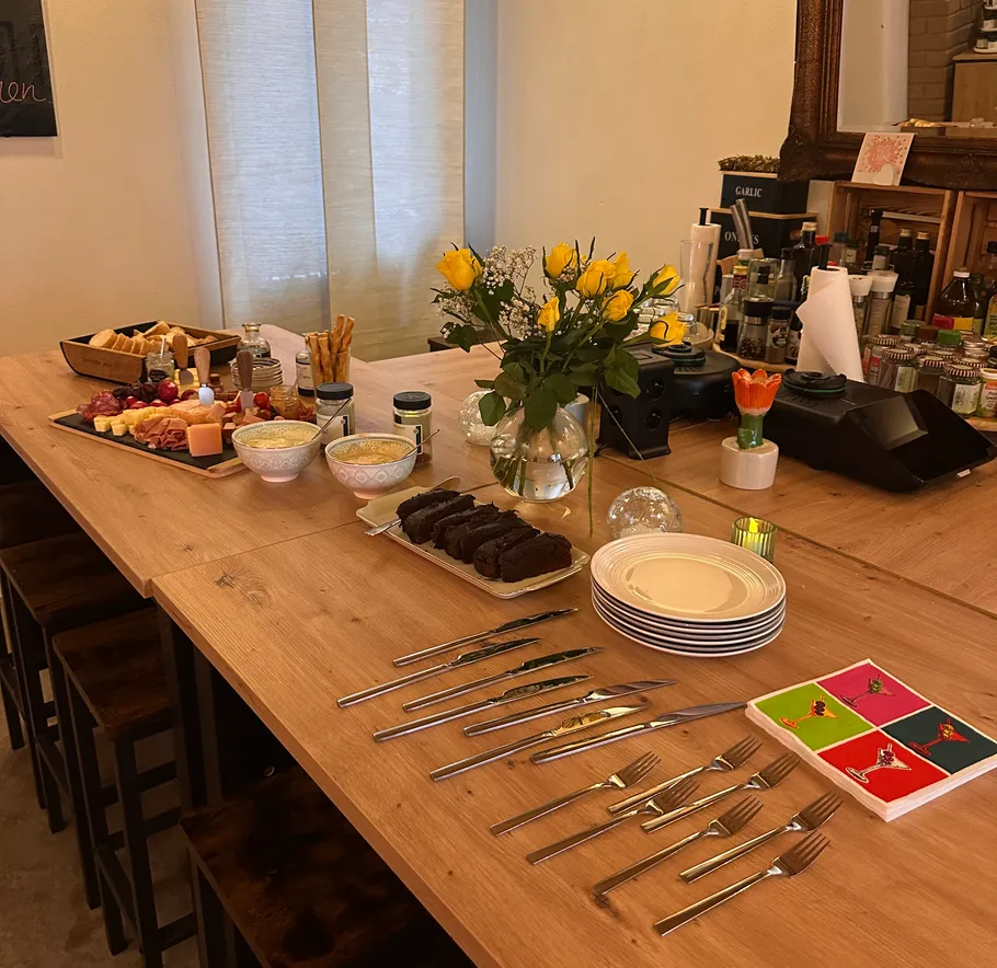 Table set with food, flowers, and utensils.