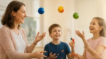 Frau und zwei Kinder jonglieren bunte Bälle drinnen.