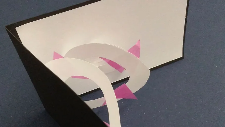 Paper sculpture with spirals on blue background.