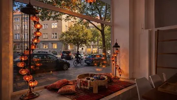 Gemütliches Café mit dekorativen Lampen und Straßenblick.