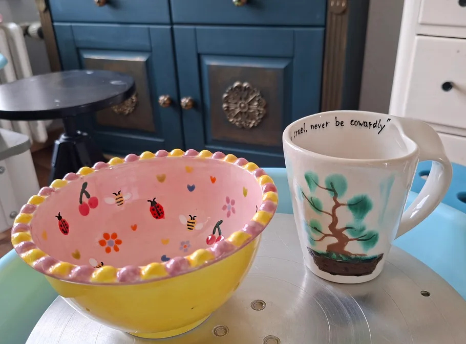 Colorful bowl and mug on tabletop, decorated kitchen.