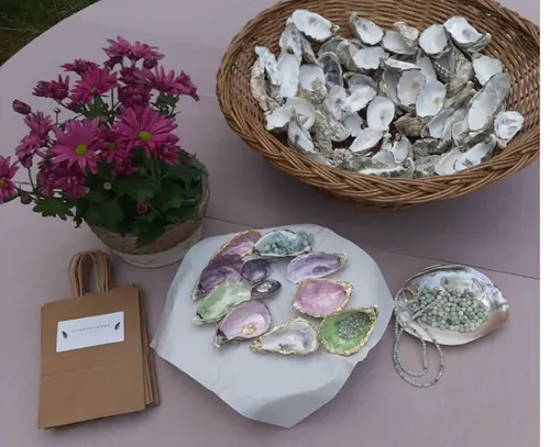Painted oyster shells and flowers on a table.