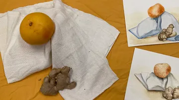 Orange und Ingwer auf weißem Tuch neben Gemälden.
