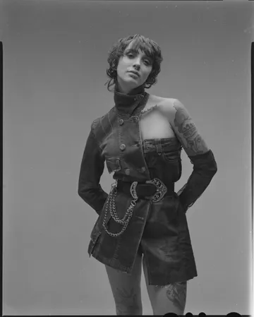 Person trägt modisches Denim-Outfit und posiert selbstbewusst.