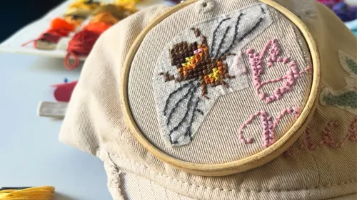 Bee embroidery on cap with colorful threads.